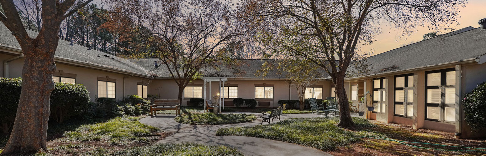 Serene courtyard with trees, benches, and winding pathway.